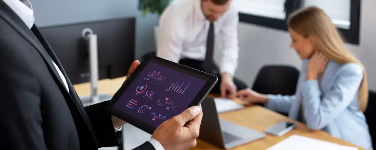 Analyse de données stratégiques sur tablette lors d'une collaboration entre partenaires professionnels.