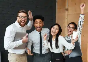 Équipe de jeunes collaborateurs diversifiée et souriante célébrant une réussite en entreprise, symbole d'inclusion et de performance globale.