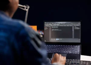 Développeur analysant du code et des techniques de prompt engineering sur un ordinateur portable