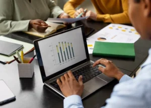 Professionnel concevant un mini-outil interactif et des graphiques de données sur ordinateur portable à partir d'un tableur.