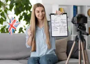 Jeune enseignante tenant un drapeau britannique et un schéma de grammaire pour un cours d'anglais