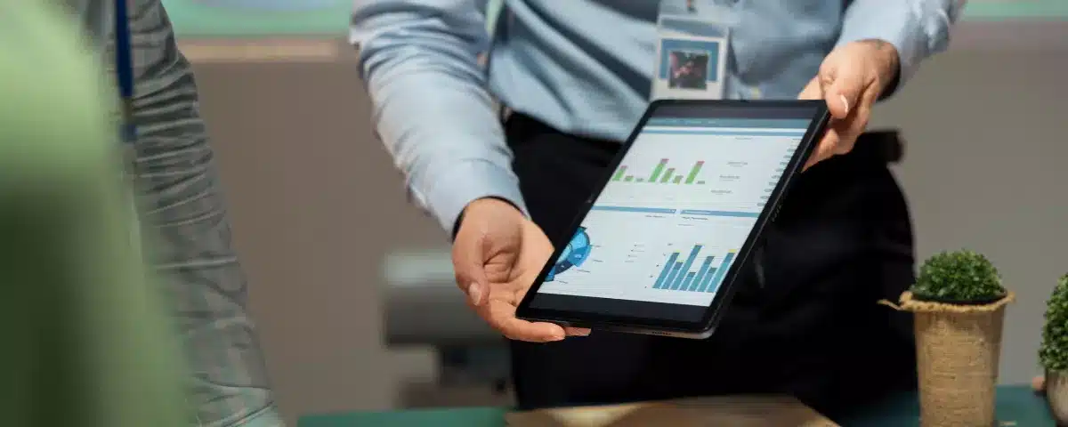 Présentation d'un tableau de bord d'analyse de données sur tablette numérique en entreprise.
