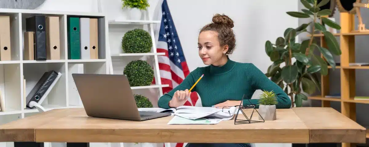 Femme passant un test d'anglais professionnel en ligne sur ordinateur avec drapeau américain en fond